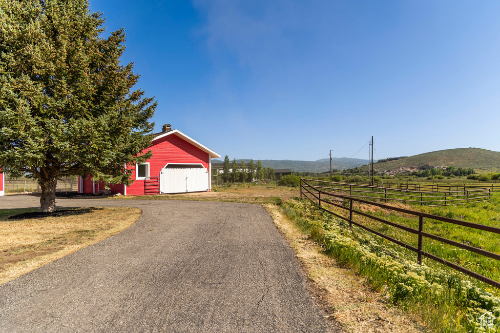 View of asphalt driveway with a mountain view and a view of rural / pastoral area