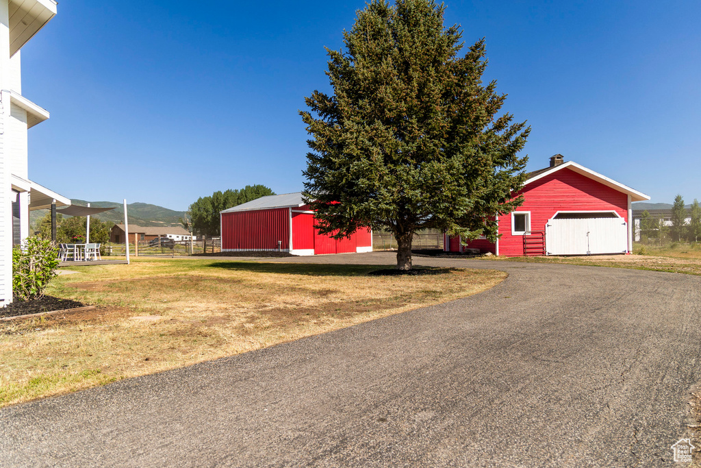View of yard with an outbuilding, an outdoor structure, a mountain view, and a detached garage