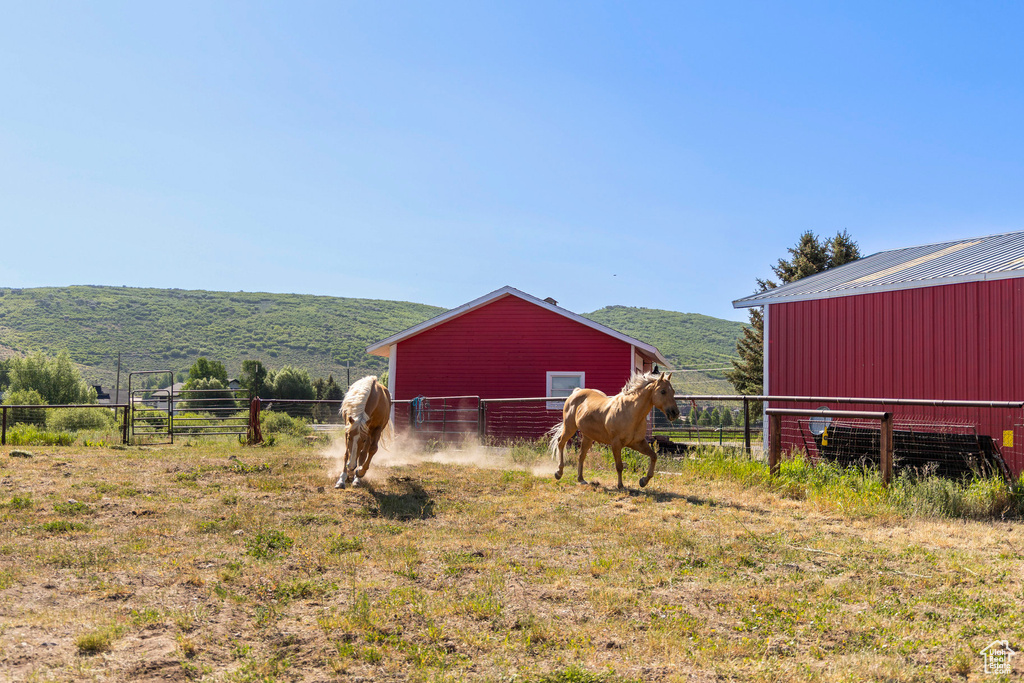 View of yard featuring a pole building, an outbuilding, a rural view, and a mountain view