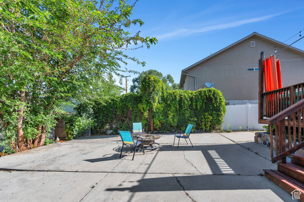 Fenced backyard featuring a patio area, a fire pit, and stairs