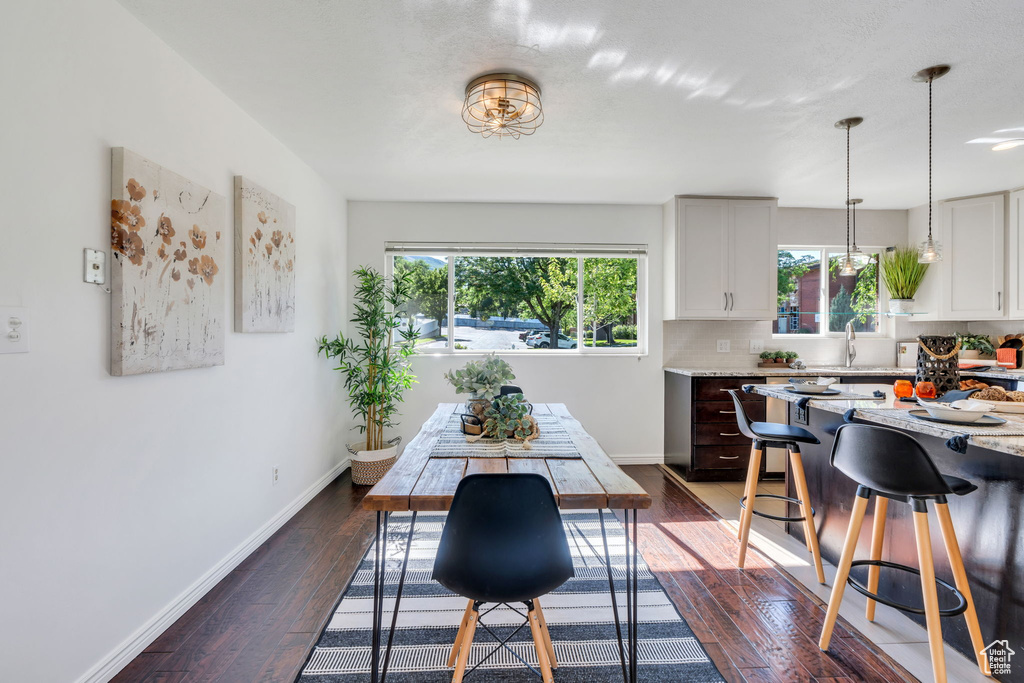 Dining space with dark wood finished floors and baseboards