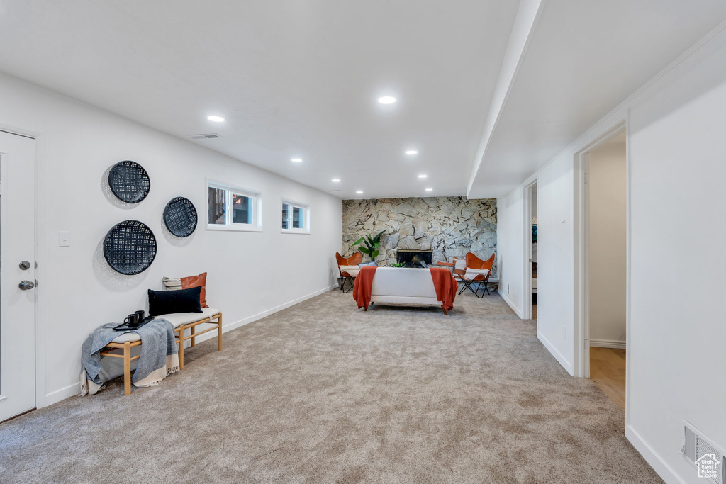 Carpeted living area featuring recessed lighting and a stone fireplace