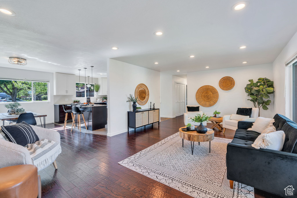 Living room with recessed lighting and dark wood-style flooring