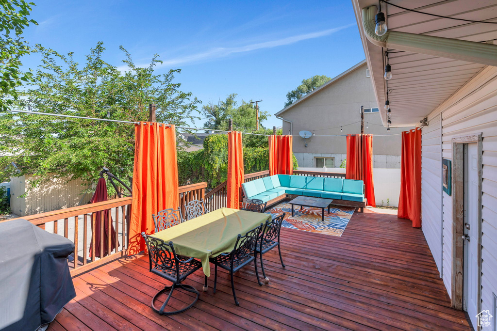 Wooden deck with outdoor lounge area, area for grilling, and outdoor dining space