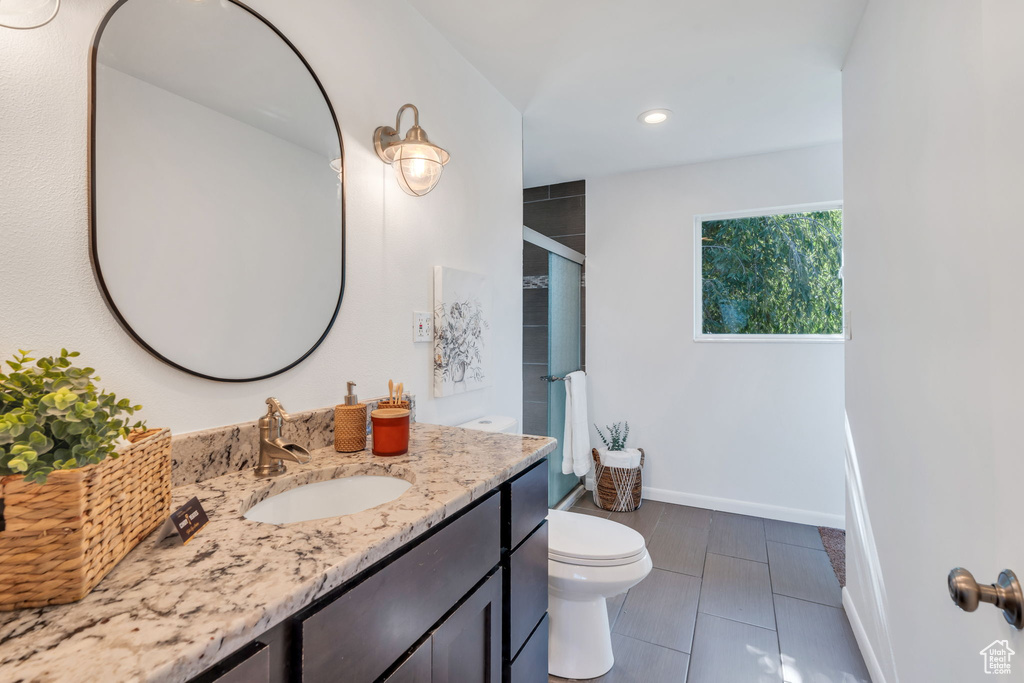 Bathroom featuring a shower with shower door, vanity, recessed lighting, and tile patterned floors
