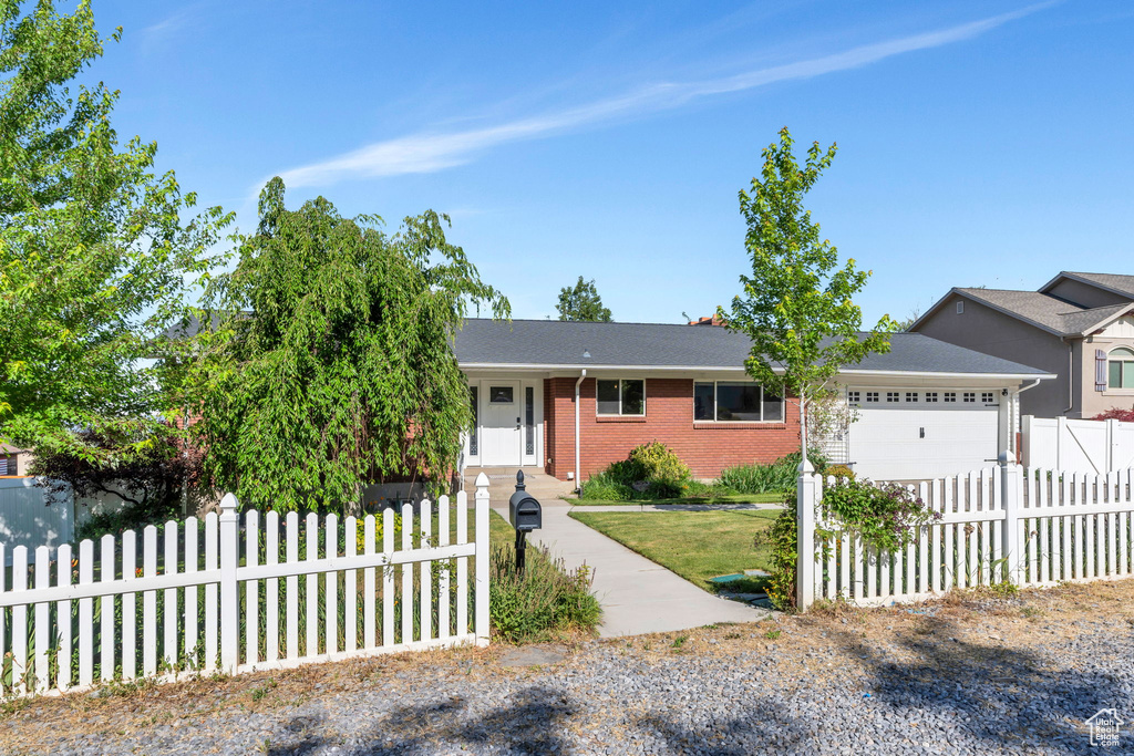 Single story home with an attached garage, brick siding, and driveway
