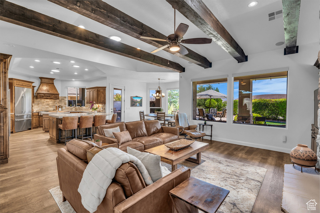 Living area featuring recessed lighting, light wood-style floors, beamed ceiling, a chandelier, and ceiling fan