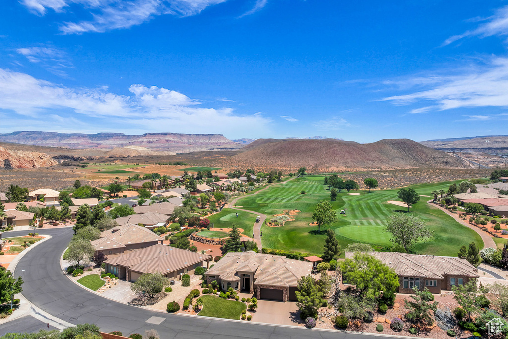 Aerial view of residential area with a mountain backdrop and a local golf course