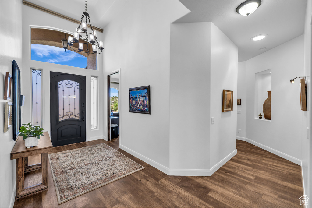 Entrance foyer featuring a chandelier, dark wood-style flooring, and a high ceiling