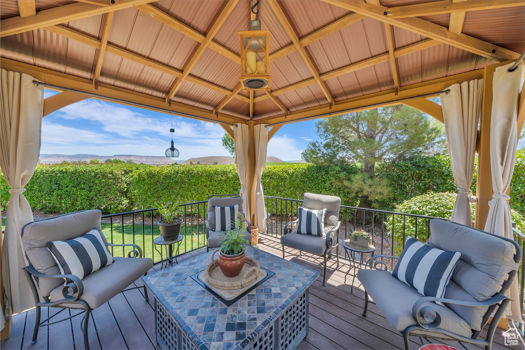 Wooden deck featuring an outdoor living space, a gazebo, and a mountain view