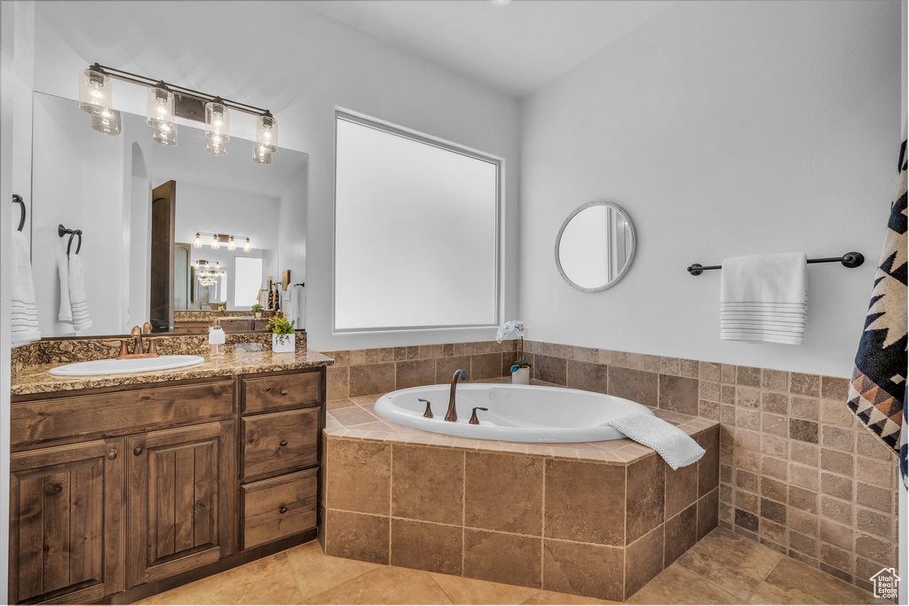 Bathroom featuring vanity, a bath, and tile patterned floors