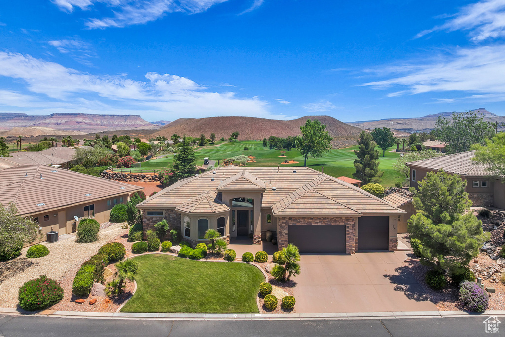 View of front of house featuring an attached garage, driveway, and a mountain view