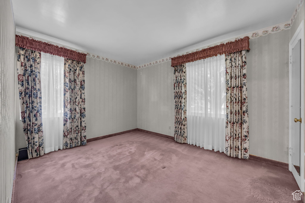 Carpeted empty room featuring baseboards