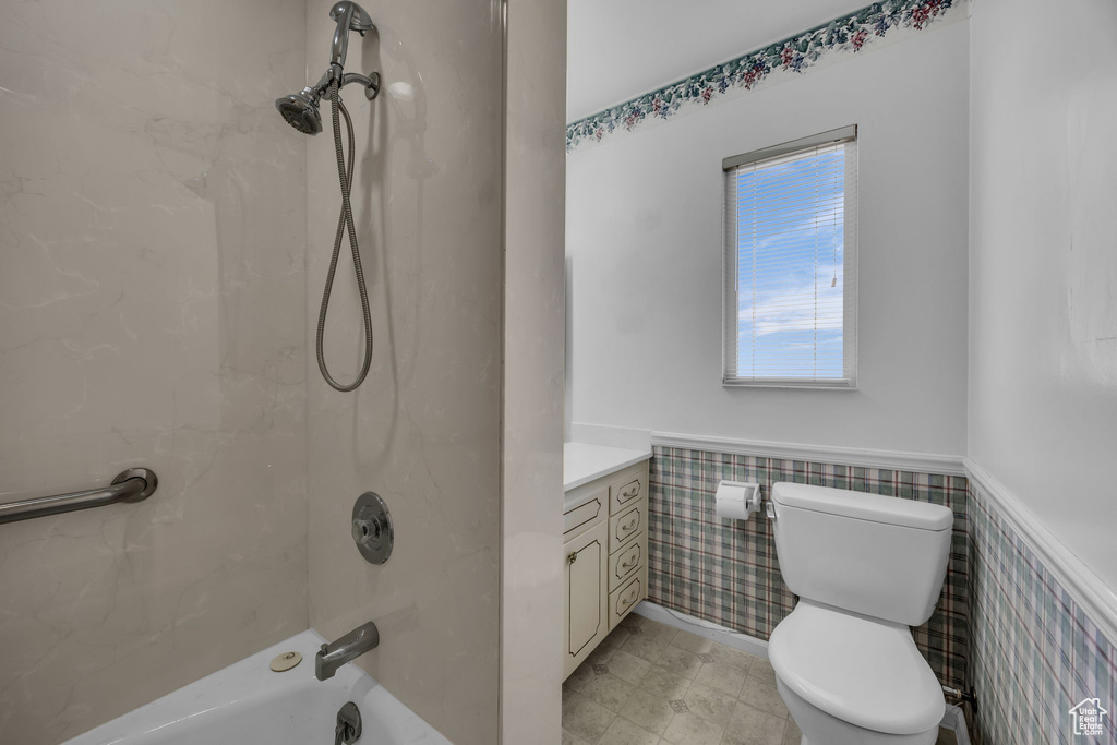 Full bathroom with wainscoting, washtub / shower combination, and vanity