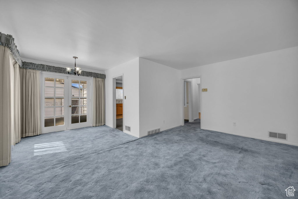 Carpeted empty room with a chandelier