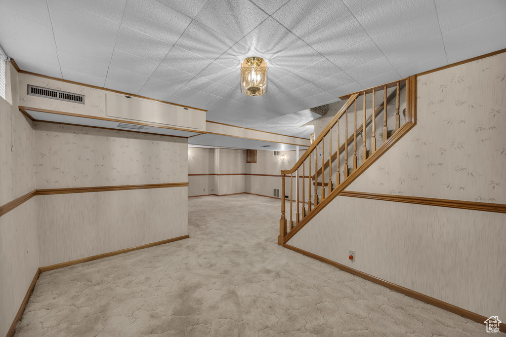 Finished basement with stairway, carpet, and wallpapered walls