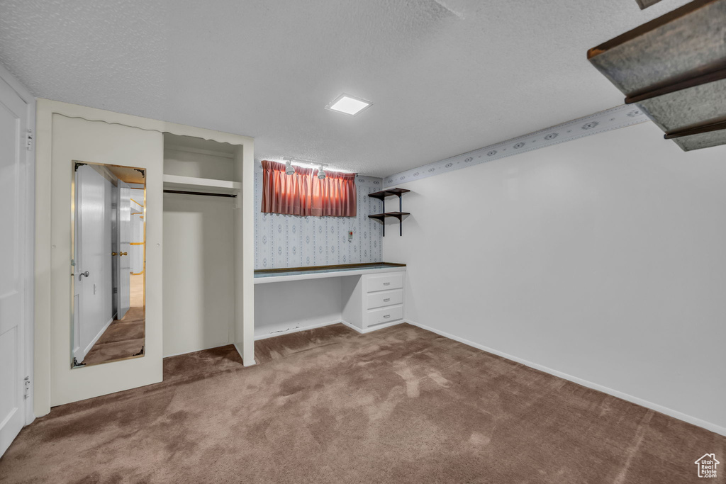 Unfurnished bedroom featuring carpet floors, a closet, and a textured ceiling