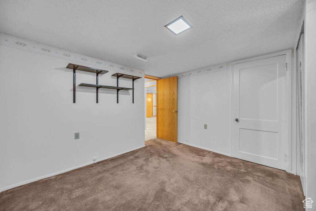Carpeted spare room featuring baseboards