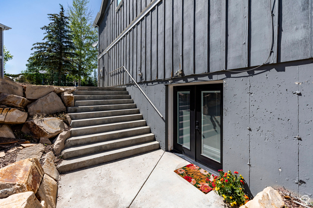 Property entrance featuring board and batten siding and french doors