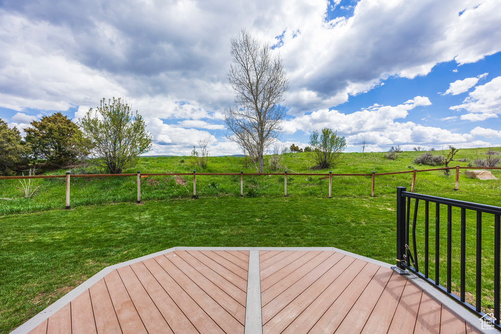 Deck with a view of countryside and a lawn