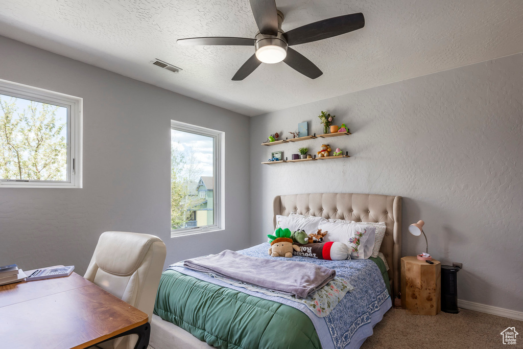 Bedroom featuring a textured ceiling, carpet floors, and a ceiling fan