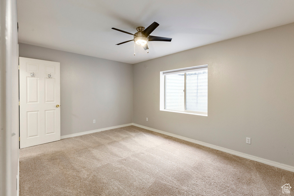 Spare room featuring carpet and a ceiling fan