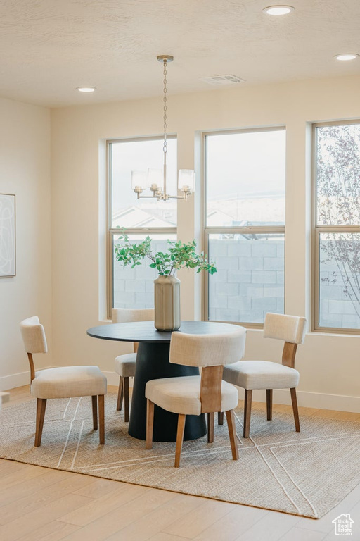 Dining room featuring wood finished floors, recessed lighting, plenty of natural light, and a chandelier