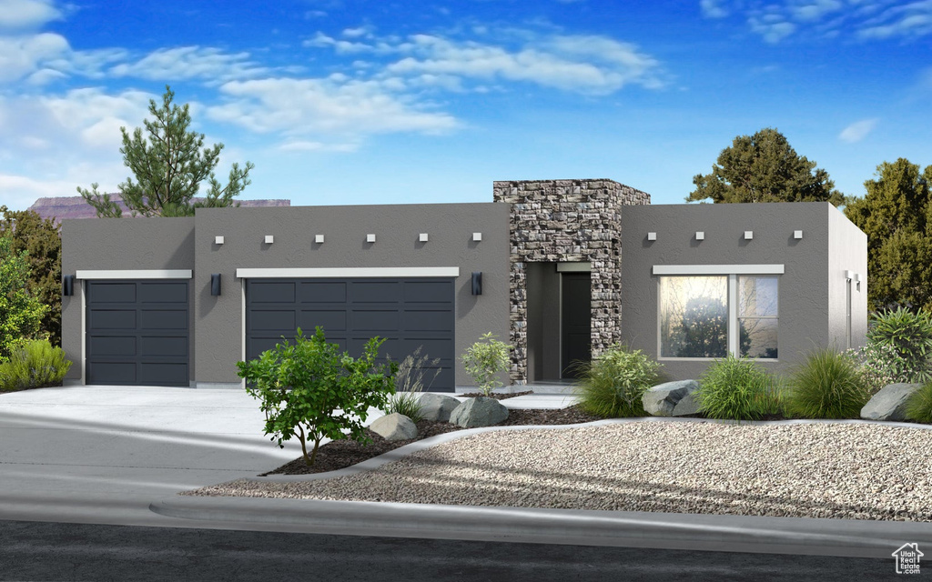 Contemporary home featuring an attached garage, stucco siding, and driveway