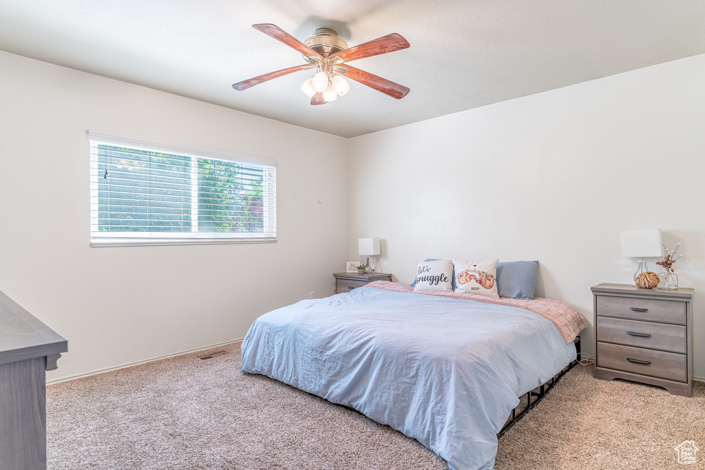 Carpeted bedroom featuring a ceiling fan and baseboards