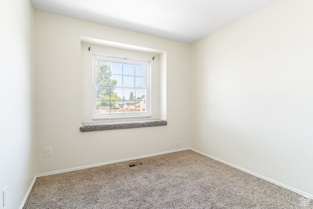Carpeted spare room with baseboards