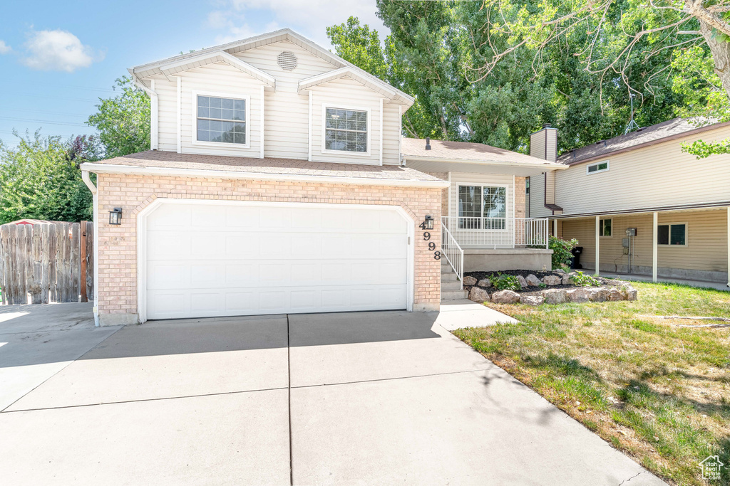 View of front facade with concrete driveway, brick siding, and a garage