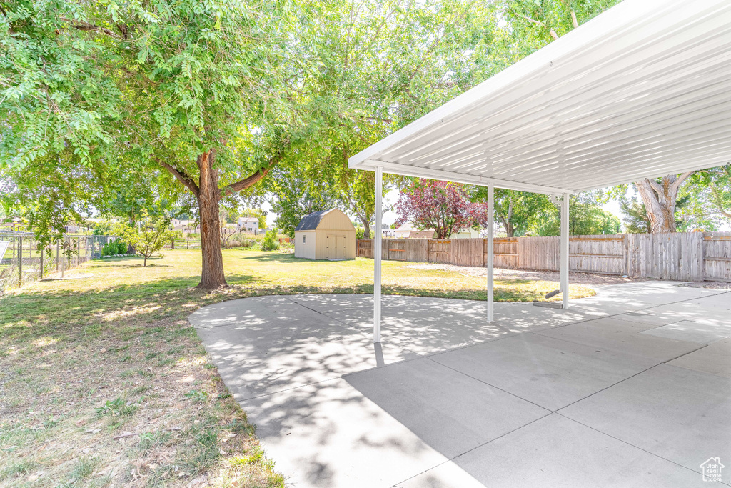 Fenced backyard with a storage shed and a patio area