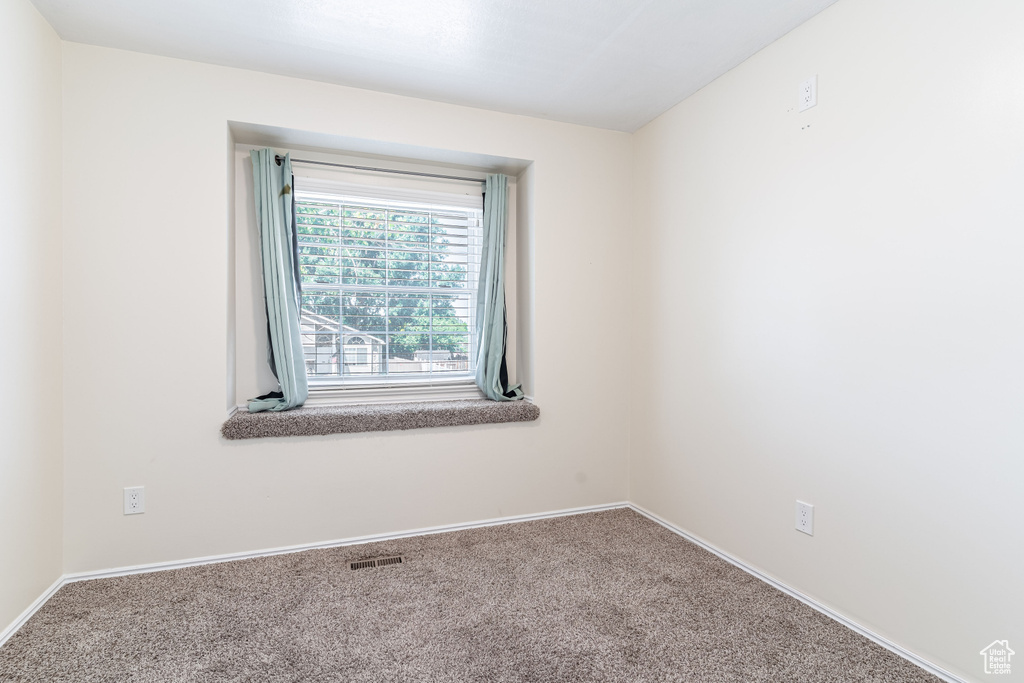 Carpeted empty room with baseboards