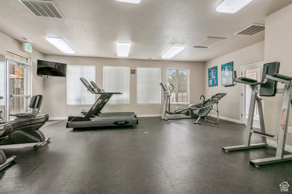 Exercise room featuring a textured ceiling and healthy amount of natural light