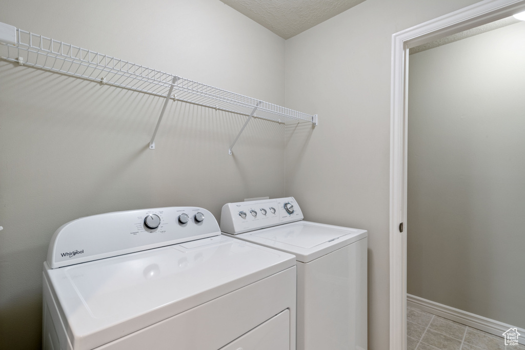 Laundry room featuring washing machine and clothes dryer and baseboards