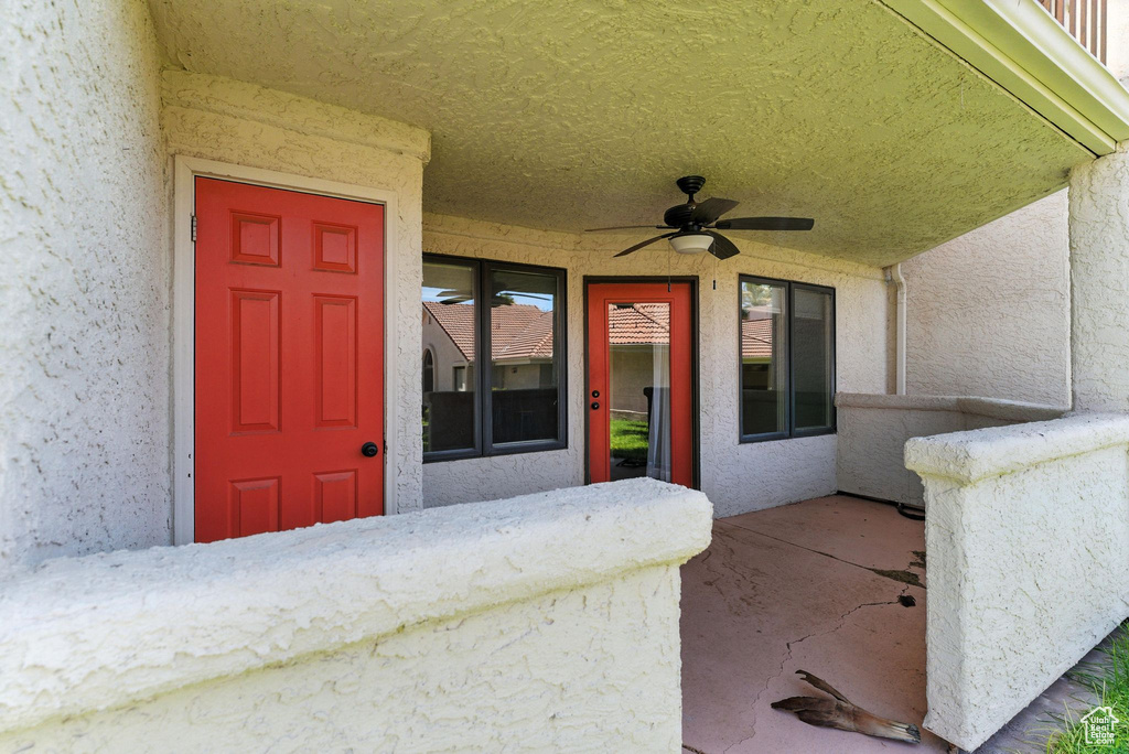View of exterior entry featuring stucco siding and ceiling fan