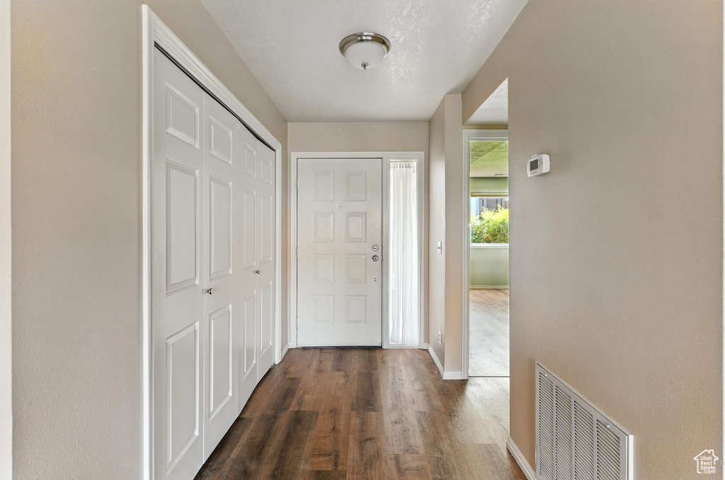 Foyer featuring dark wood-type flooring and baseboards