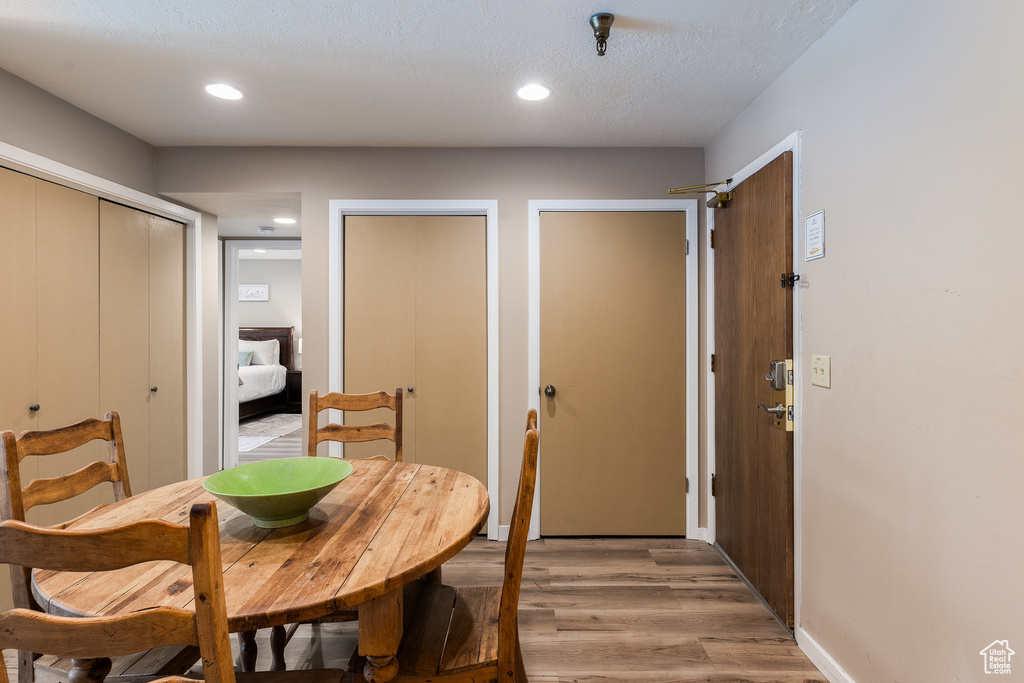 Dining room with light wood-style flooring and recessed lighting