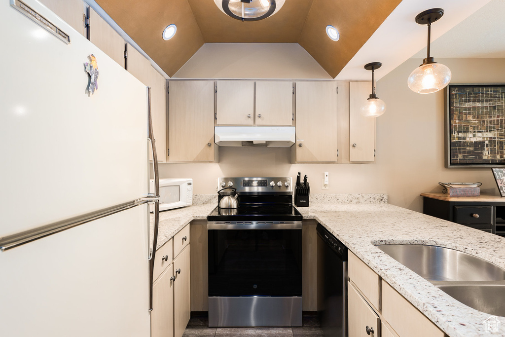 Kitchen featuring white appliances, under cabinet range hood, pendant lighting, and light stone counters
