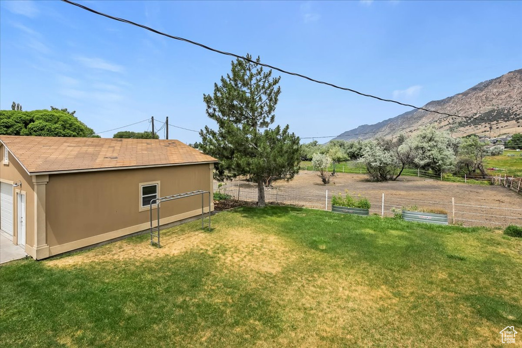 View of yard with a garden, a mountain view, and a garage