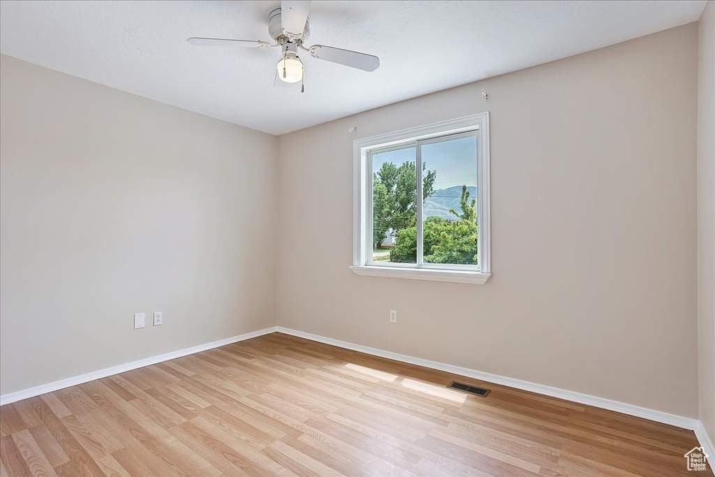 Empty room with light wood finished floors and ceiling fan