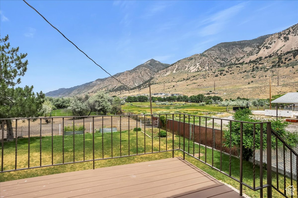 Wooden deck featuring a view of countryside and a mountain view