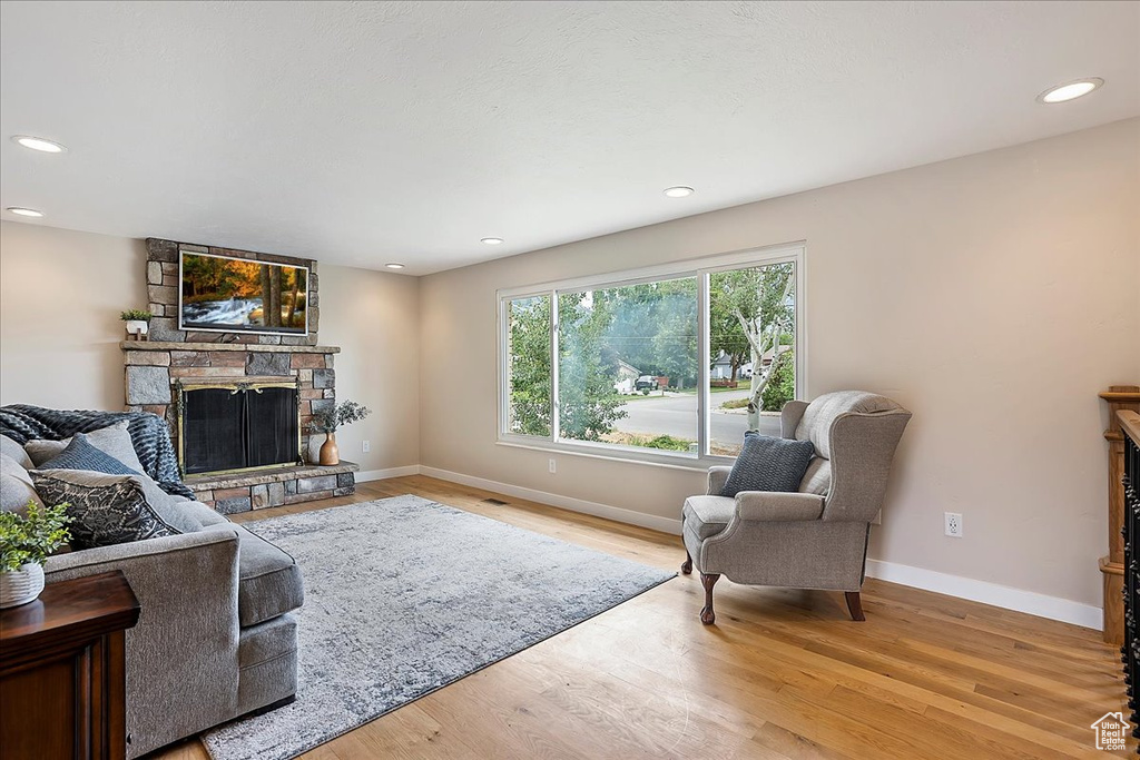 Living area with a fireplace, recessed lighting, and wood finished floors