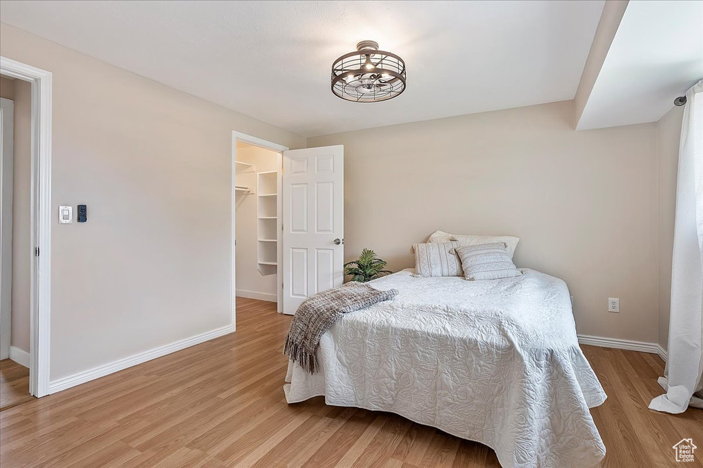 Bedroom with light wood-style floors and a walk in closet