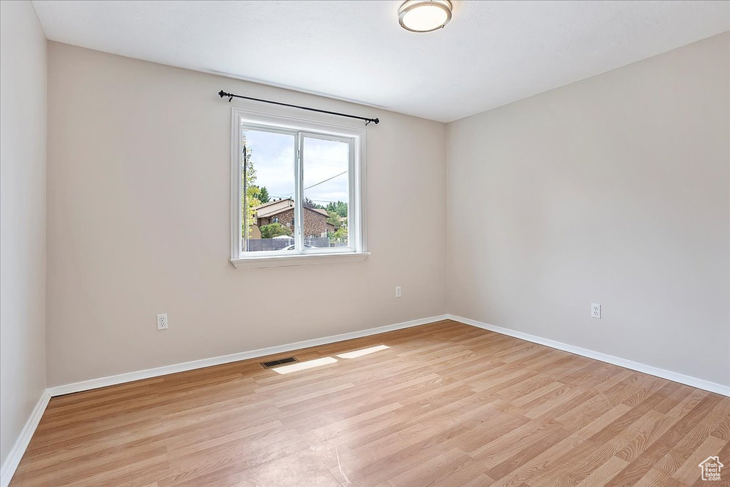 Empty room with light wood-type flooring and baseboards