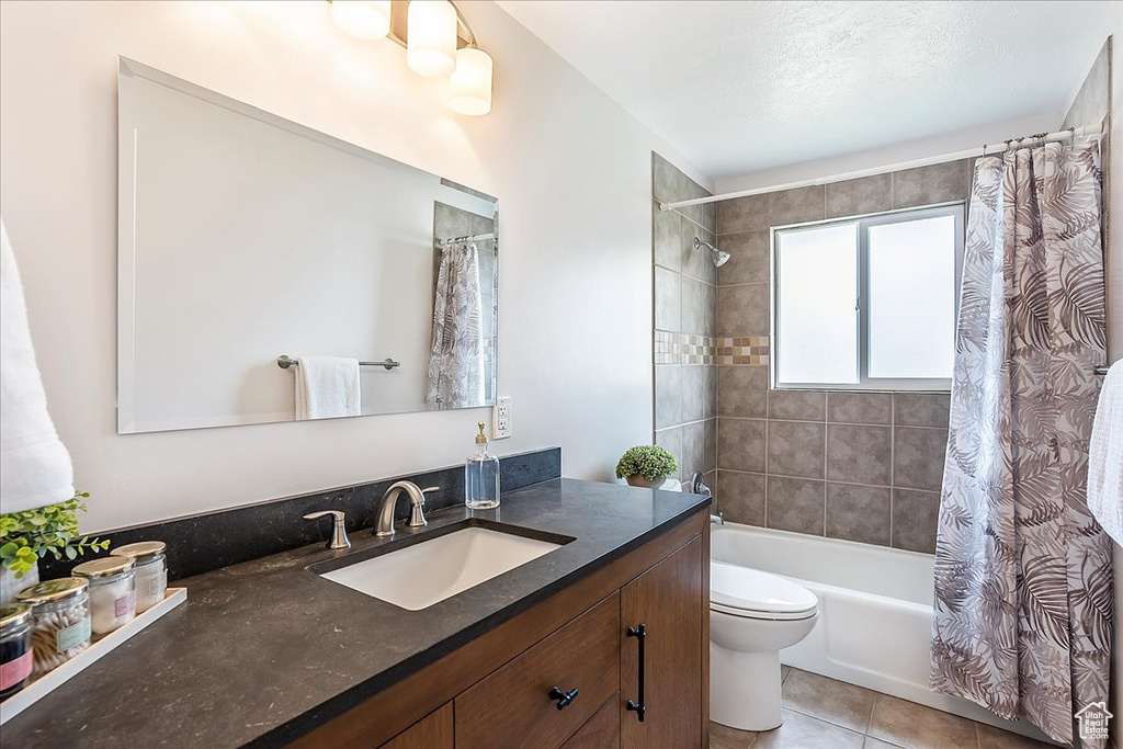 Full bath with vanity, shower / bathtub combination with curtain, and tile patterned flooring