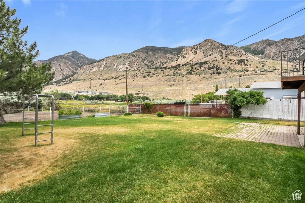 View of yard featuring a mountain view, a patio, and a vegetable garden