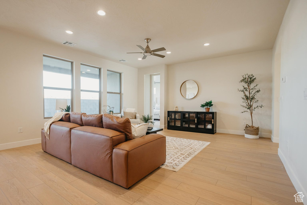 Living room with light wood-style floors, a ceiling fan, and recessed lighting