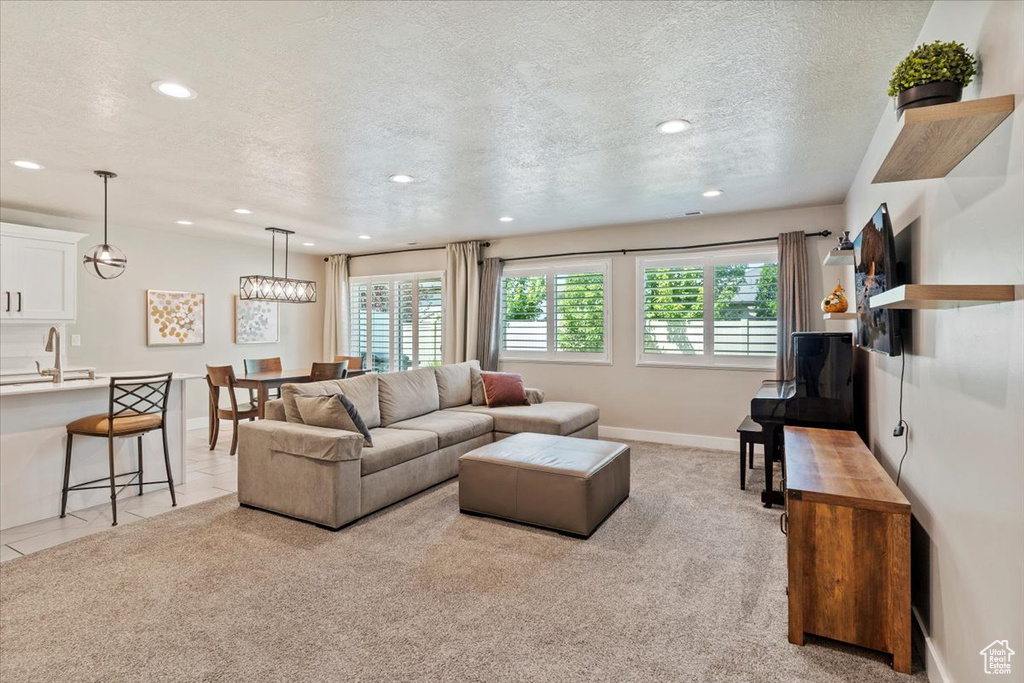 Living area with recessed lighting, a textured ceiling, and light colored carpet