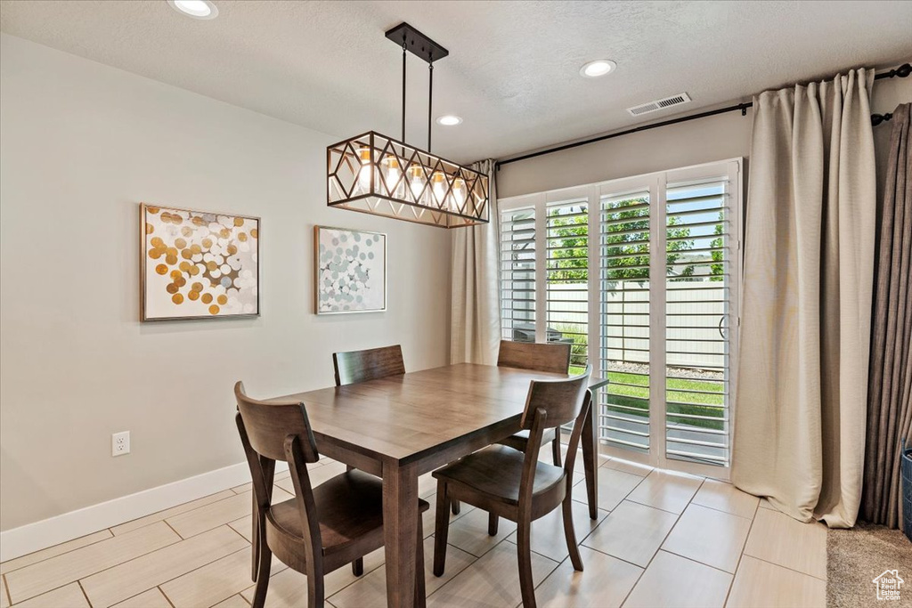 Dining area featuring recessed lighting, light tile patterned flooring, and a textured ceiling